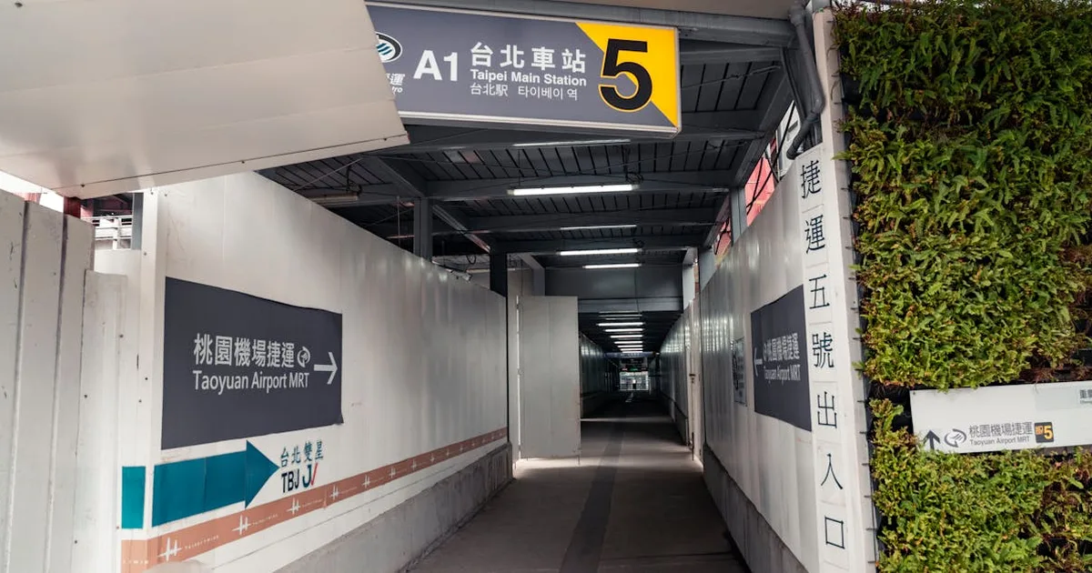 Covered walkway leading to Taipei Main Station Exit 5 with signs to Taoyuan Airport MRT.