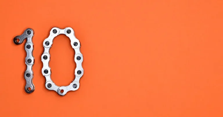 Bicycle chain arranged to form the number ten against a bright orange background.
