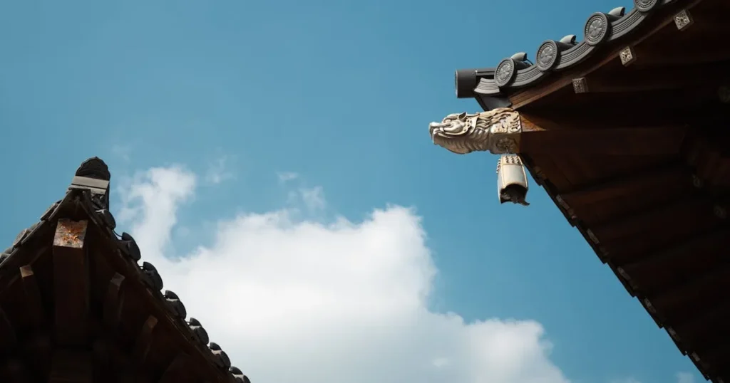 Close-up of a traditional Chinese roof with ornamental detail against a clear blue sky.