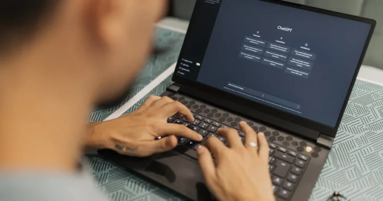 A focused individual types on a laptop running AI software indoors.