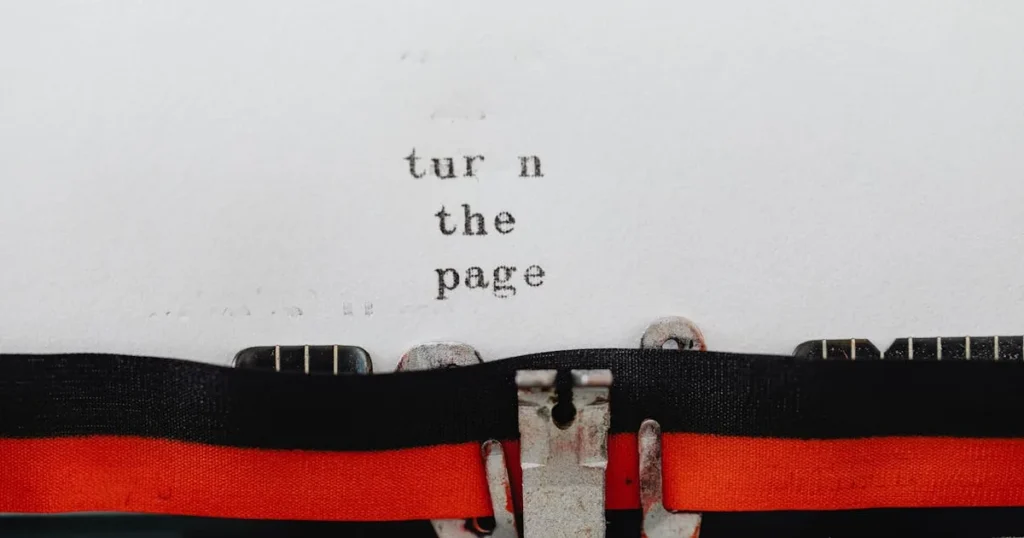 Close-up of a vintage typewriter with text 'turn the page' typed on paper, symbolizing change and ne