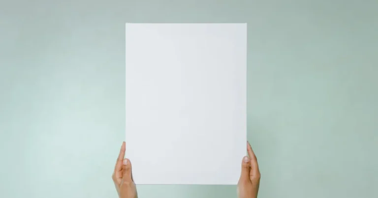 Simple blank canvas held hands on light green background with copy space.