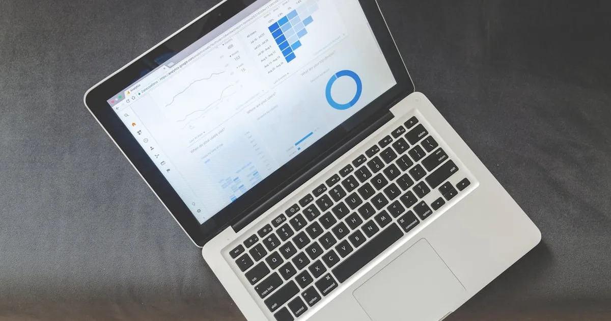 Overhead view of a laptop showing data visualizations and charts on its screen.
