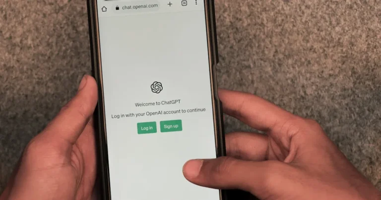 Close-up of hands using smartphone with ChatGPT app open on screen.