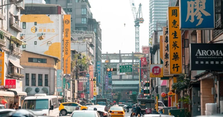 A lively urban street in Taipei, Taiwan, bustling with traffic and colorful signage.