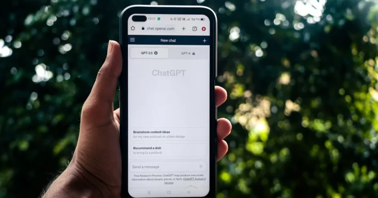 A person uses ChatGPT on a smartphone outdoors, showcasing technology in daily life.