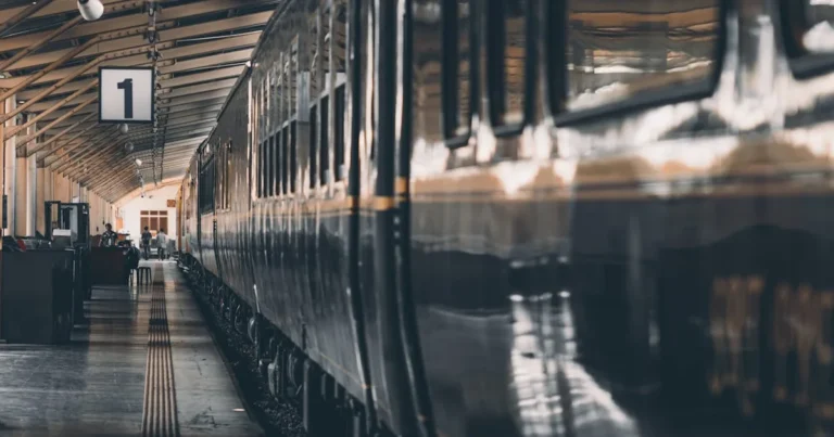 A classic train at an empty railway platform, with a warm and moody atmosphere.