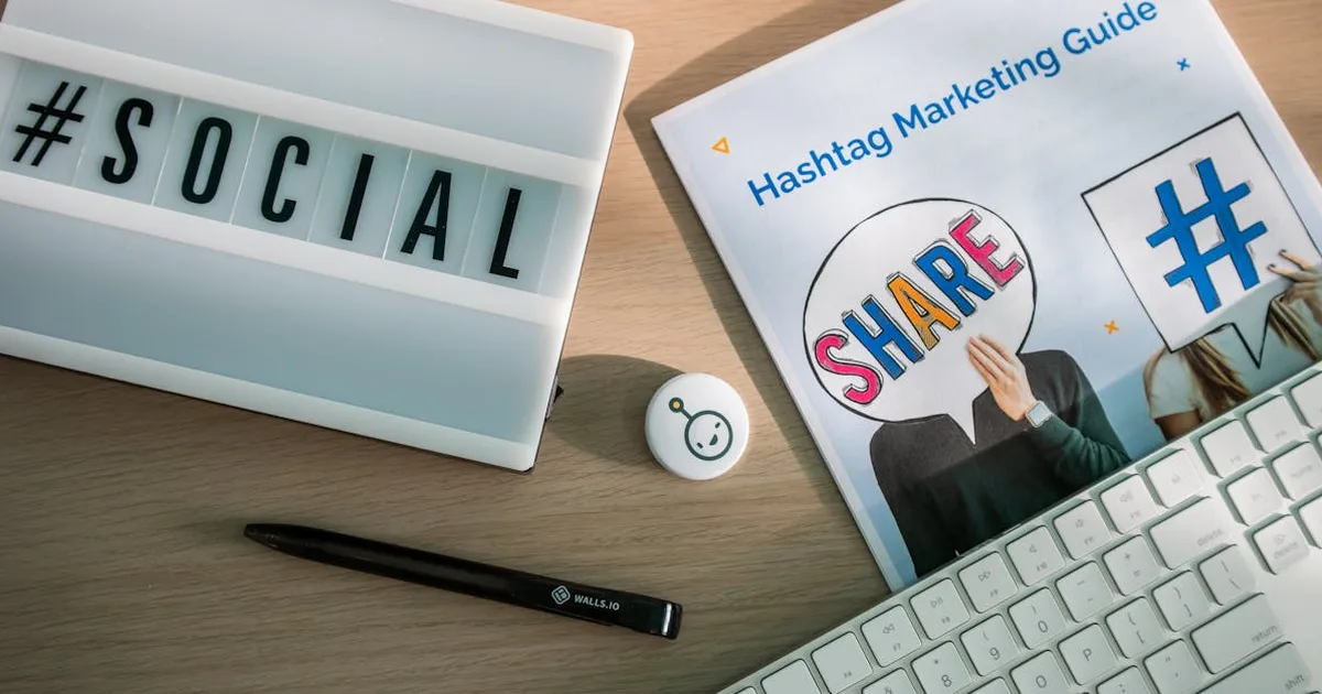A desktop setup with social media marketing essentials including a keyboard, lightbox, and guide.